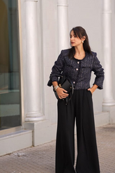 a lady in a sequin tweed jacket and a pair of black wide leg pants